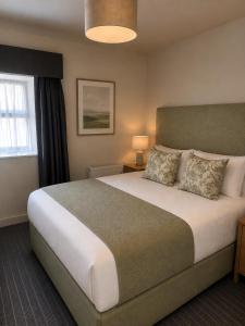 a bedroom with a large bed and a window at Powerscourt Arms Hotel in Enniskerry