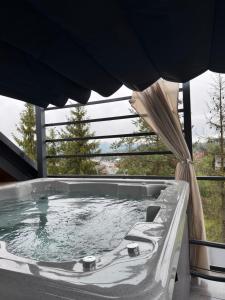 a jacuzzi tub in a house with a window at Rabczański Taras z jacuzzi i otwieranym dachem in Rabka-Zdrój