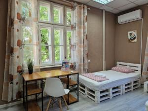 a room with a bed and a desk and a window at Lambo's Corner Varna - Guest Rooms in Varna City