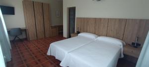 a bedroom with a white bed and wooden walls at Casa Milor in Cabrafigal
