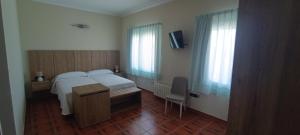 a bedroom with a bed and a desk and window at Casa Milor in Cabrafigal