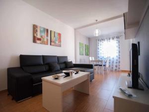 a living room with a couch and a table at Livingtarifa Apartamento Los Lances in Tarifa