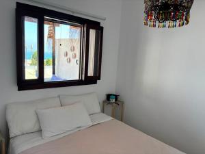 a bedroom with a white bed with a window at Maison de plage Marsa M'diq 2 chambres et Salon in M'diq