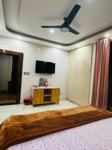 a living room with a flat screen tv and a couch at Dhauladhar Vista in Pālampur