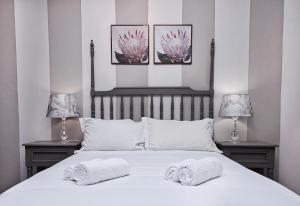 a bedroom with two towels on a bed with two lamps at Rundu B&B in Rundu