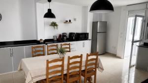 a kitchen with a table with chairs and a refrigerator at Spacious villa, sea view in Cabo Negro