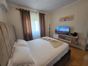 a bedroom with a bed and a flat screen tv at Asea Apartaments in Golem