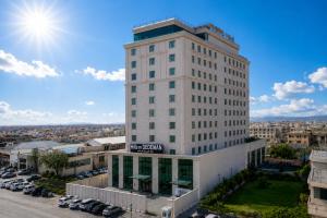 a tall white building with a sign on it at Hills Managed by Dedeman in Erbil