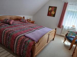 a bedroom with a wooden bed and a chair at Ferienwohnung Lenhardt in Barkenholm