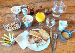 a table with a plate of bread and other breakfast foods at Chambres La Prévôté - Randonneurs et Pèlerins - Ancien couvent contre la Cathédrale in Le Puy-en-Velay +22 photos