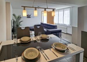 a dining room with a table with plates and wine glasses at Chalet Bellevue Beautiful Waterfall view private Garden & free parking in Lauterbrunnen