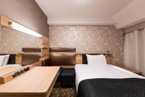 a hotel room with two beds and a desk at APA Hotel Kyoto Gion Excellent in Kyoto +59 photos