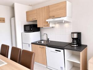a small kitchen with a sink and a refrigerator at La TERRASSE in Salavas