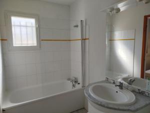 a bathroom with a tub and a sink and a bath tub at La TERRASSE in Salavas