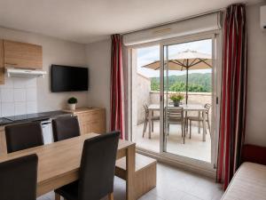 a kitchen and dining room with a table with an umbrella at La TERRASSE in Salavas