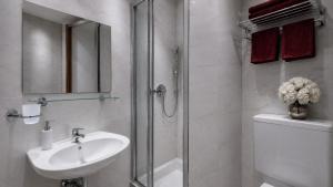a bathroom with a shower and a sink and a toilet at Hotel AI Königshof in Berlin +44 photos