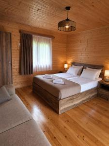 a bedroom with a large bed and a couch at Ushba Hill Panoramic Lodge Becho in Mestia