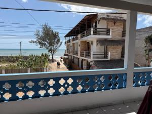 a balcony with a view of the beach and a building at Pousada Flor de Sal in Prea