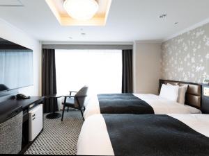 a hotel room with two beds and a television at APA Hotel Kyoto Gion Excellent in Kyoto