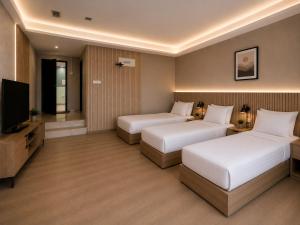 a hotel room with two beds and a flat screen tv at Citto Inn Bangi in Bandar Baru Bangi
