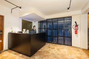 a woman standing at a reception desk in a room at Sam's Apartment in Pātan