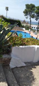 a swimming pool with a white planter in front of it at Maison de plage Marsa M'diq 2 chambres et Salon in M'diq +14 photos