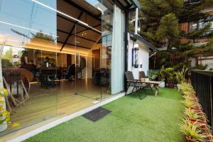 a glass extension of a house with a lawn at Sam's Apartment in Pātan