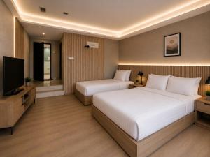 a hotel room with two beds and a flat screen tv at Citto Inn Bangi in Bandar Baru Bangi