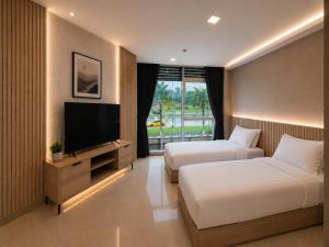 a hotel room with two beds and a flat screen tv at Citto Inn Bangi in Bandar Baru Bangi