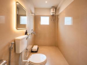 a bathroom with a white toilet and a mirror at Hotel Puri Waves - Near Blue Flag Beach - Restautant, Parking & Spa in Puri