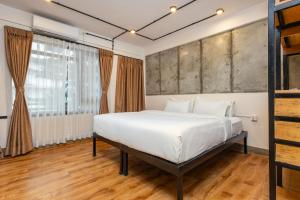 a bedroom with a large bed with white sheets at Sam's Apartment in Pātan