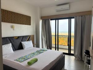 a bedroom with a bed and a large window at Chez Gero Aeroport in Cotonou +24 photos