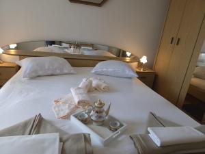 a white bed with a tray with a tea set on it at Casa Maja in Karlobag