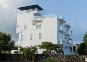 a white building with a balcony on the side of it at Villa Clasic Comfort in Navalur
