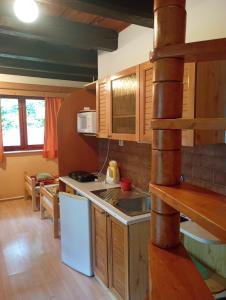 a kitchen with wooden cabinets and a white refrigerator at Chalupa Mlyn Dolný Kubín in Dolný Kubín
