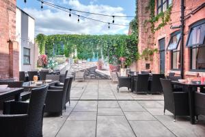 a patio of a restaurant with tables and chairs at Kings Park Hotel in Retford