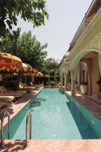 a swimming pool with chairs and umbrellas next to a building at Casa Fontana in Alaçatı
