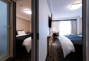 a hotel room with two beds and a window at APA Hotel Kyoto Gion Excellent in Kyoto