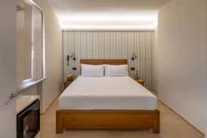 a bedroom with a large bed with white sheets at Hotel de La Ville - Self Check-In in Fidenza