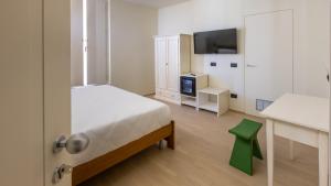 a bedroom with a bed and a table and a tv at Hotel de La Ville - Self Check-In in Fidenza