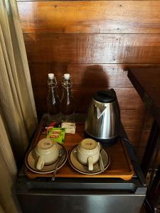 a stove top with a tea kettle and two glass bottles at Zen Tree House in Silebeng