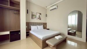 a bedroom with a bed and a stool in it at Ann Arbor Hotel in Ho Chi Minh City