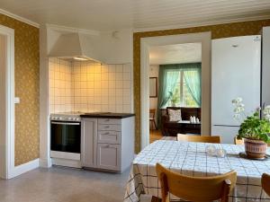 a kitchen and dining room with a table and a kitchen with a stove at Boende i Sandarne in Sandarne