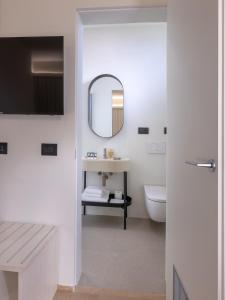 a white bathroom with a sink and a mirror at Hotel de La Ville - Self Check-In in Fidenza +9 photos
