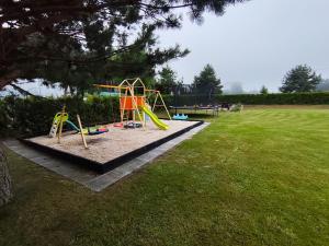 a playground with a slide in a park at Domki Sielankowo in Odargowo