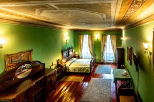 a bedroom with green walls and a bed with a mirror at Hotel Casa Wagner in Sighişoara +64 photos