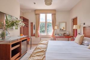 a hotel room with a bed and a desk at Kings Park Hotel in Retford +42 photos