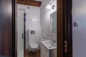 a white bathroom with a toilet and a sink at Gościniec Lila in Mikołajki +23 photos