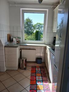 a kitchen with a window and a tile floor at Ferienwohnung Lenhardt in Barkenholm +20 photos