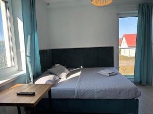 a bedroom with a bed with a table and a window at Konik Morski in Łeba